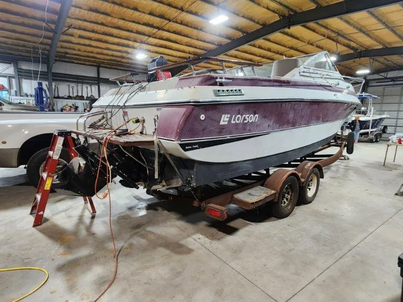 Slide: The Image of 1987 Larson 23 Cuddy Cabin boat on trailer in a garage setting. - 3