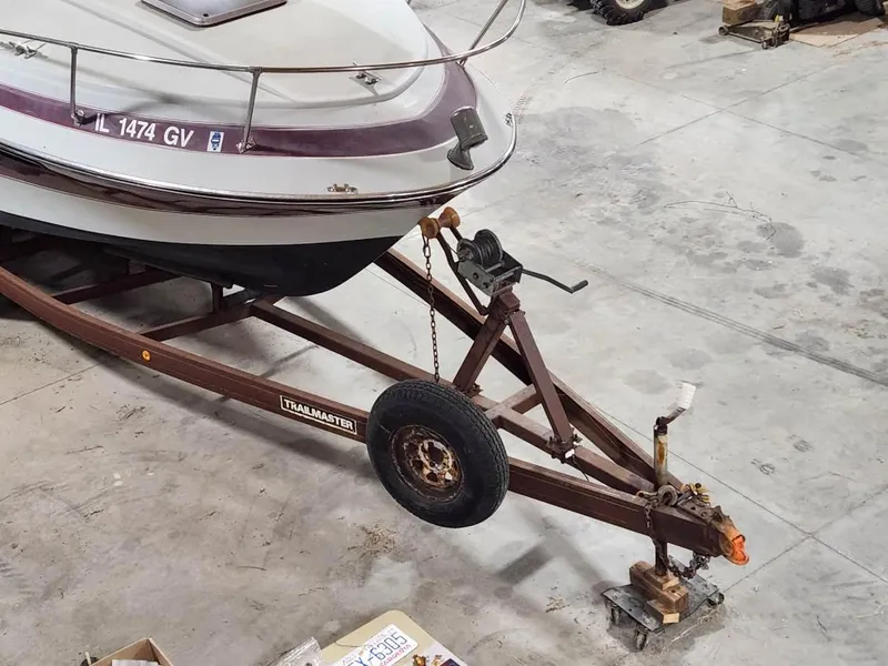 Slide: The Image of 1987 Larson 23 Cuddy Cabin boat on a trailer in a garage setting. - 4