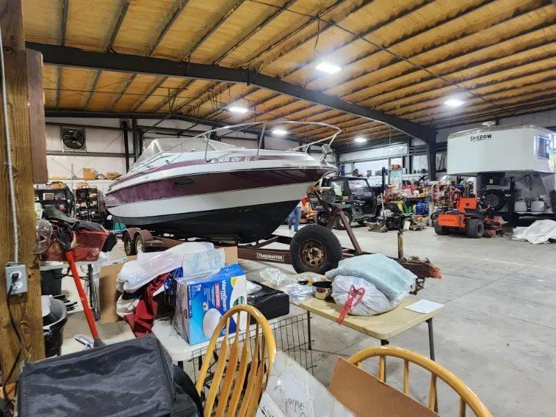 Slide: The Image of 1987 Larson 23 Cuddy Cabin boat in a cluttered workshop. - 8