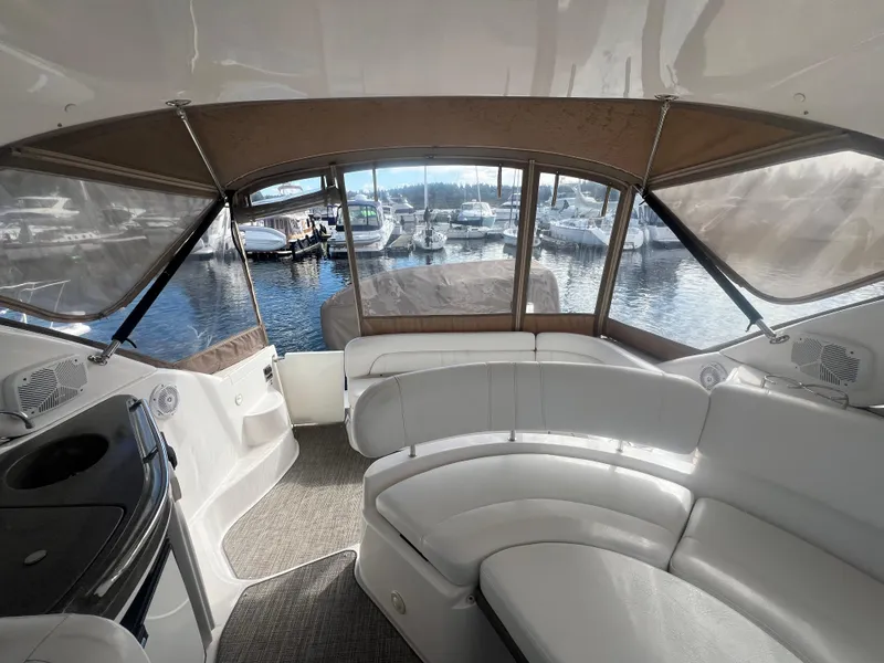 Slide: The Image of Interior view of 2007 Regal Commodore 4060 yacht with white seating and marina backdrop. - 11