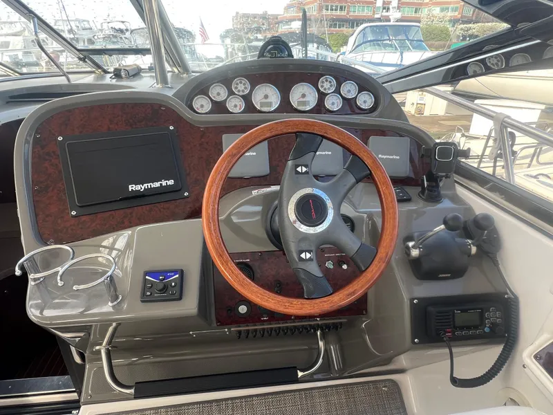 Slide: The Image of 2007 Regal Commodore 4060 yacht dashboard with wood steering wheel and navigation instruments. - 12