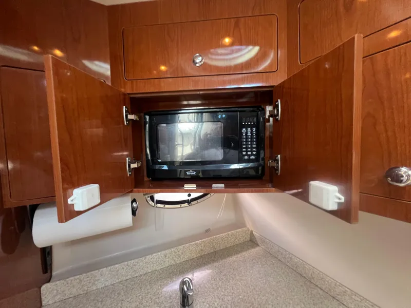 Slide: The Image of 2007 Regal Commodore 4060 yacht kitchen with microwave and wooden cabinetry. - 14