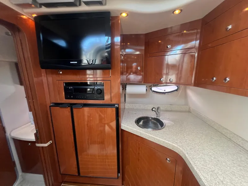 Slide: The Image of 2007 Regal Commodore 4060 yacht kitchen with wood cabinets, TV, and compact sink. - 16