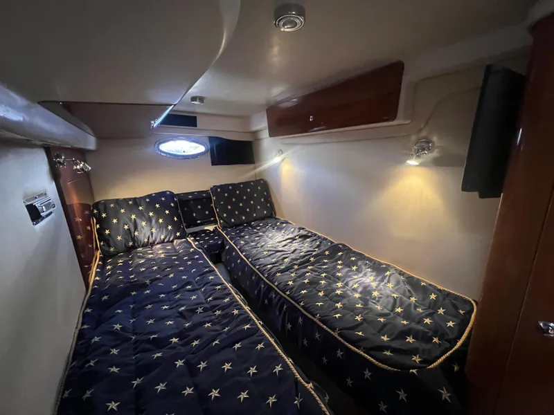 Slide: The Image of 2007 Regal Commodore 4060 cabin with twin beds and star-patterned bedding. - 24