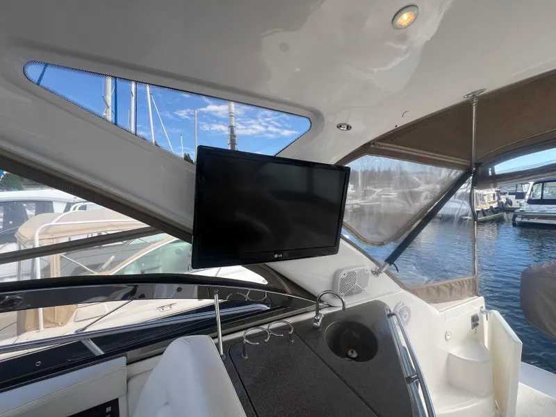 Slide: The Image of 2007 Regal Commodore 4060 yacht interior with mounted TV and marina view. - 8