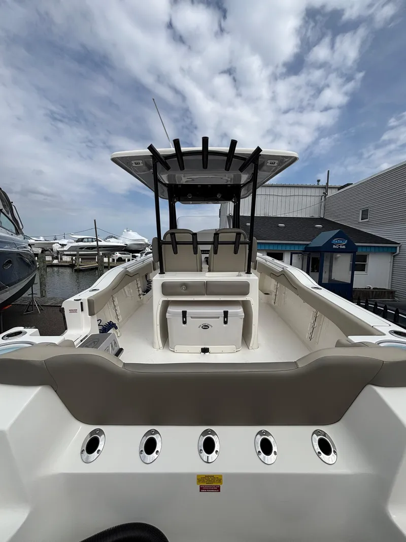 Slide: The Image of 2023 Key West 263FS boat with spacious deck and modern design at a marina. - 10