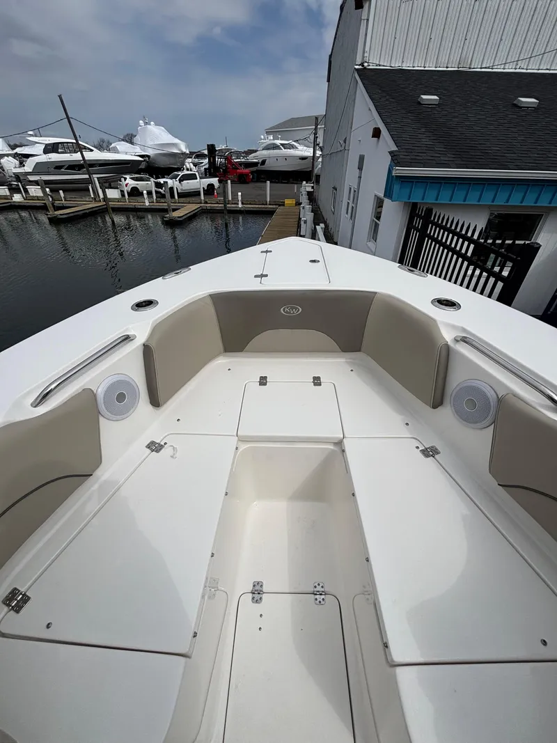 Slide: The Image of 2023 Key West 263FS boat docked at marina, showcasing spacious seating and storage. - 12