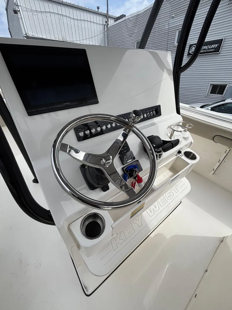 Slide: The Image of 2023 Key West 263FS boat dashboard with steering wheel and control panel. - 19