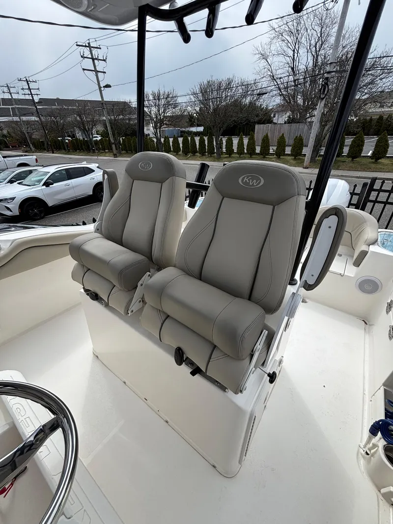 Slide: The Image of 2023 Key West 263FS boat with dual cushioned seats and steering wheel. - 21