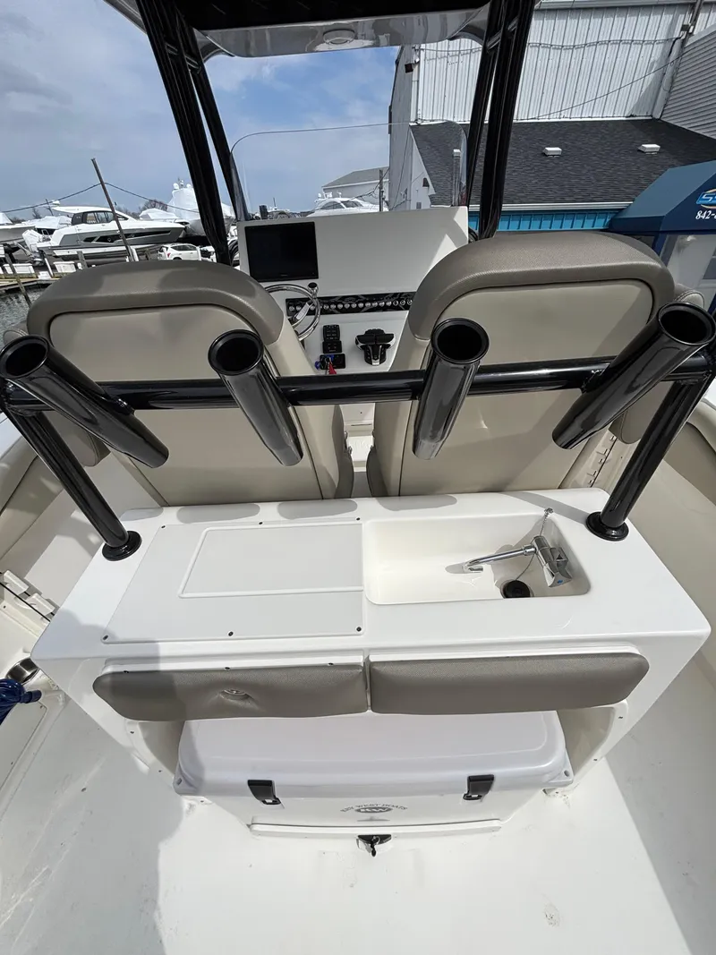 Slide: The Image of 2023 Key West 263FS boat interior with seating and rod holders at a marina. - 22