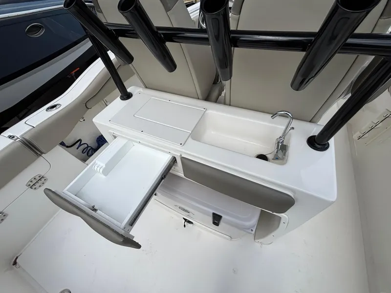 Slide: The Image of 2023 Key West 263FS boat interior with sink, storage, and rod holders. - 23