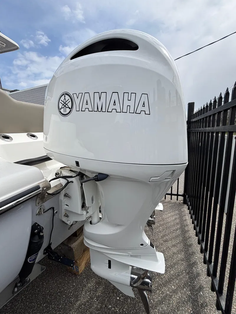 Slide: The Image of 2023 Key West 263FS boat with Yamaha outboard motor, parked near a black fence. - 3