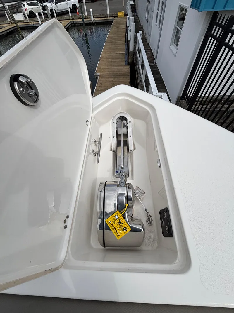 Slide: The Image of 2023 Key West 263FS boat anchor compartment with open hatch at marina. - 30