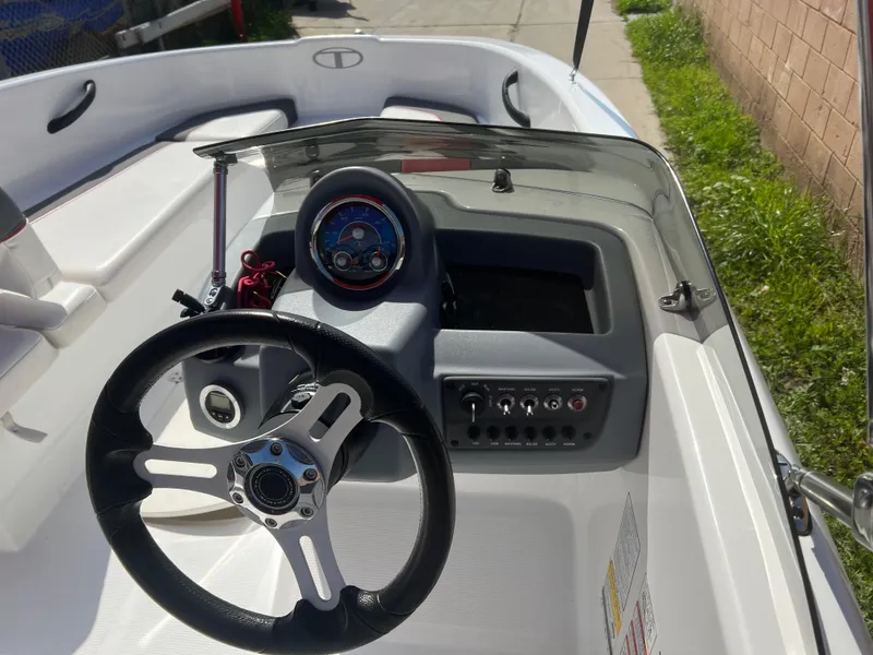 Slide: The Image of 2022 Tahoe T16 boat dashboard with steering wheel and control panel. - 10