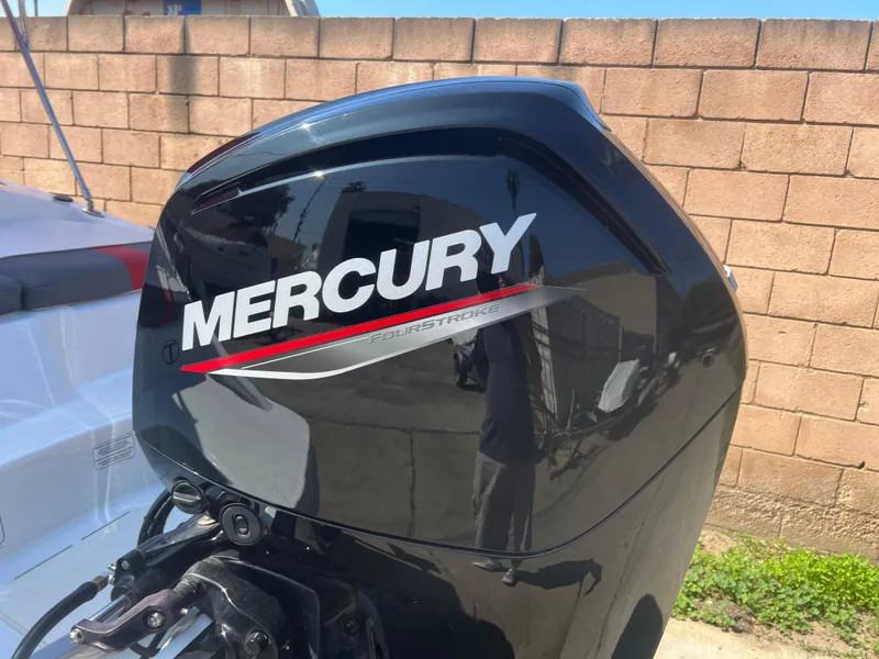 Slide: The Image of Mercury outboard motor on a 2022 Tahoe T16 boat, parked near a brick wall. - 12