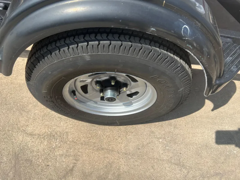 Slide: The Image of 2022 Tahoe T16 trailer tire on concrete surface, showcasing tread and wheel design. - 16