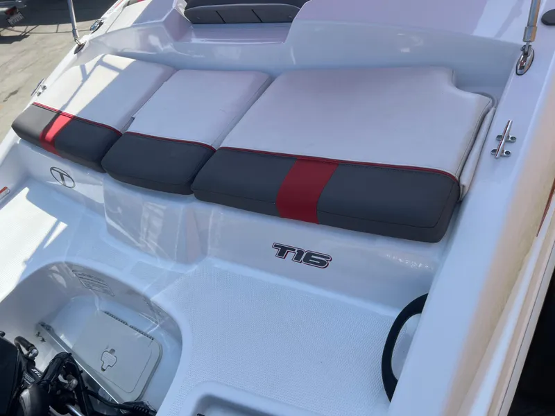 Slide: The Image of 2022 Tahoe T16 boat interior with cushioned seating and red accents. - 6