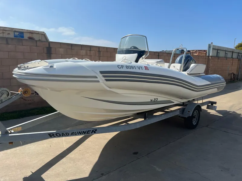 Slide: The Image of 2020 Zodiac N-ZO 600 boat on Road Runner trailer, parked outdoors. - 4