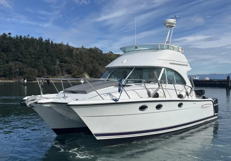 Slide: The Image of 2005 Glacier Bay 3490 Ocean Runner boat on calm water, with forested shoreline in background. - 0