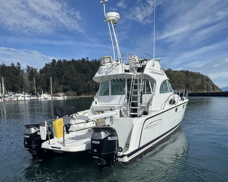 Slide: The Image of 2005 Glacier Bay 3490 Ocean Runner boat on water, featuring dual Suzuki engines. - 11