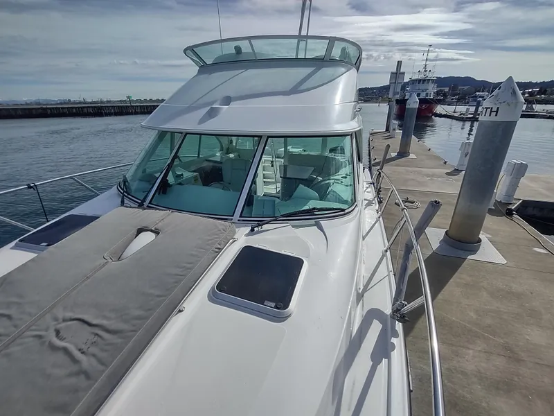 Slide: The Image of 2005 Glacier Bay 3490 Ocean Runner docked at marina, showcasing sleek design and spacious deck. - 18