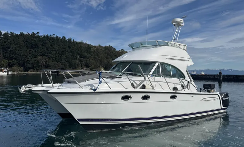 Slide: The Image of 2005 Glacier Bay 3490 Ocean Runner boat on calm water, scenic background. - 3