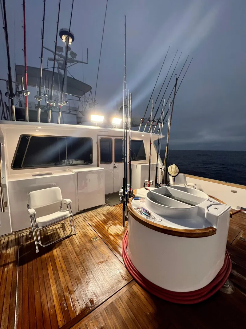 Slide: The Image of 1967 Elliott Yachtfisher with fishing rods, wooden deck, and ocean backdrop at dusk. - 13