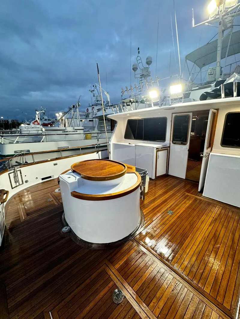 Slide: The Image of 1967 Elliott Yachtfisher with polished wooden deck at dusk in marina. - 14
