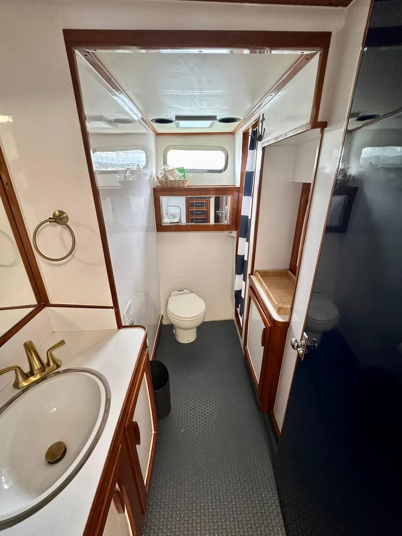 Slide: The Image of 1967 Elliott Yachtfisher bathroom with sink, toilet, mirror, and wooden accents. - 9