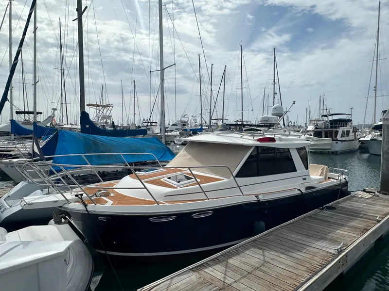The Image of 2016 Cutwater 28 boat docked in a marina, surrounded by other vessels. - 1