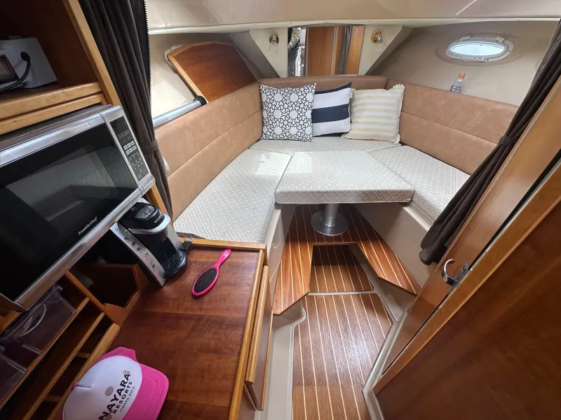 Slide: The Image of 2016 Cutwater 28 interior with cozy seating, microwave, and wooden flooring. - 10