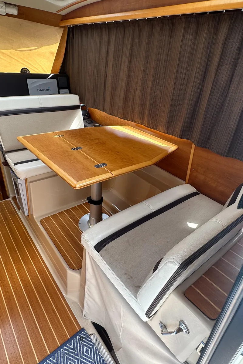 Slide: The Image of 2016 Cutwater 28 interior with wooden table and seating, featuring elegant design and wood flooring. - 13