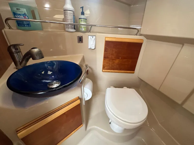 Slide: The Image of Compact bathroom in a 2016 Cutwater 28 boat with blue sink and toilet. - 14
