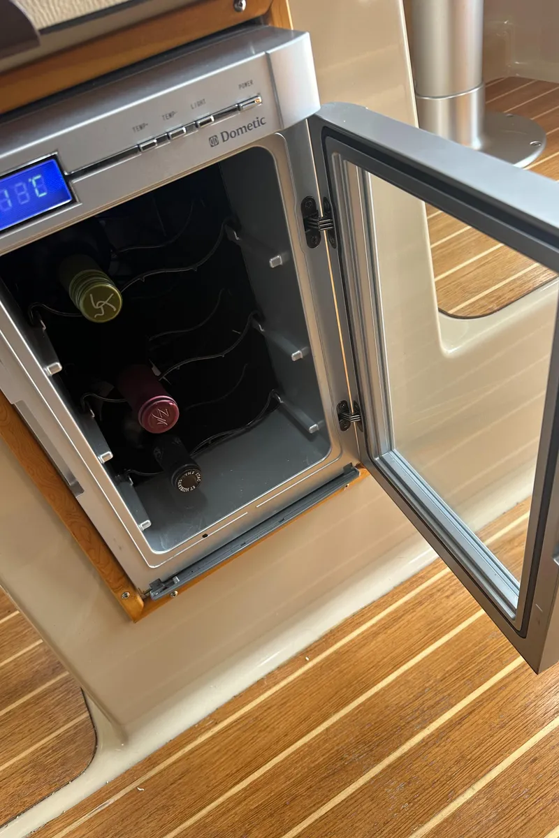 Slide: The Image of Open wine cooler on 2016 Cutwater 28 boat with wooden flooring. - 19