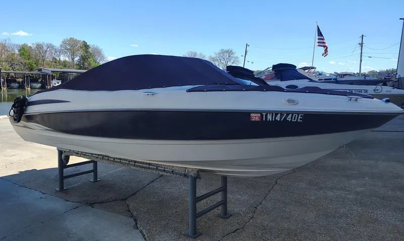 Slide: The Image of 2000 Maxum 1900 SR boat on stand, covered, with American flag in background. - 14