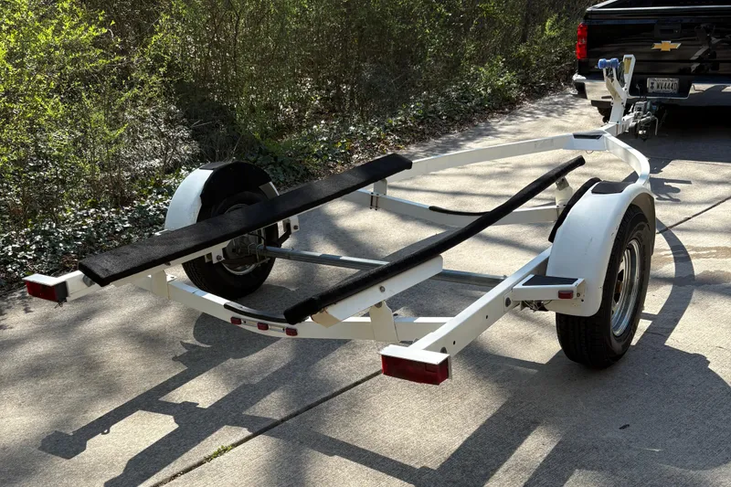 Slide: The Image of Boat trailer for 2000 Maxum 1900 SR, parked on a sunlit driveway. - 16