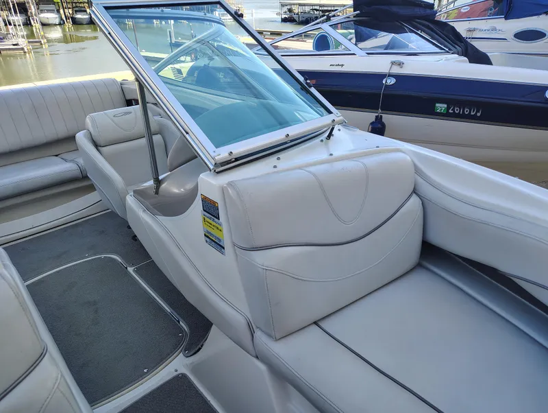 Slide: The Image of 2000 Maxum 1900 SR boat interior with white seating and windshield, docked at marina. - 8
