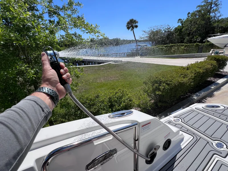 Slide: The Image of Person using a hose on a 2022 Monterey M45 boat, scenic waterfront view. - 30