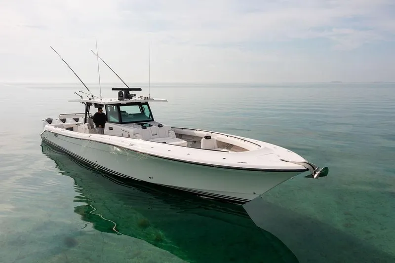 Slide: The Image of 2019 HCB 53 boat on calm, clear water with fishing rods. - 26