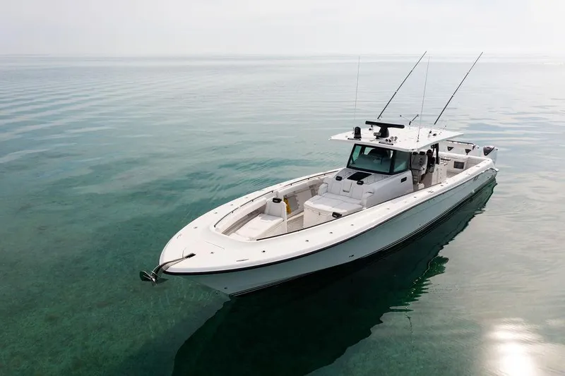 Slide: The Image of 2019 HCB 53 boat on calm, clear water with fishing rods. - 28