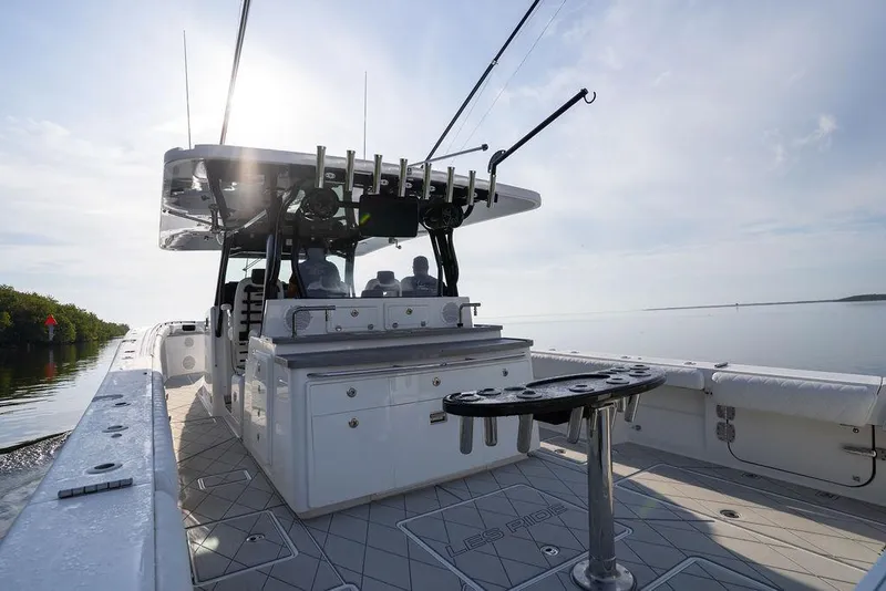 Slide: The Image of 2019 HCB 53 boat with fishing setup, cruising on calm waters under a clear sky. - 29
