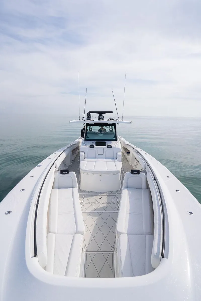 Slide: The Image of 2019 HCB 53 boat with spacious deck and sleek design on calm water. - 42