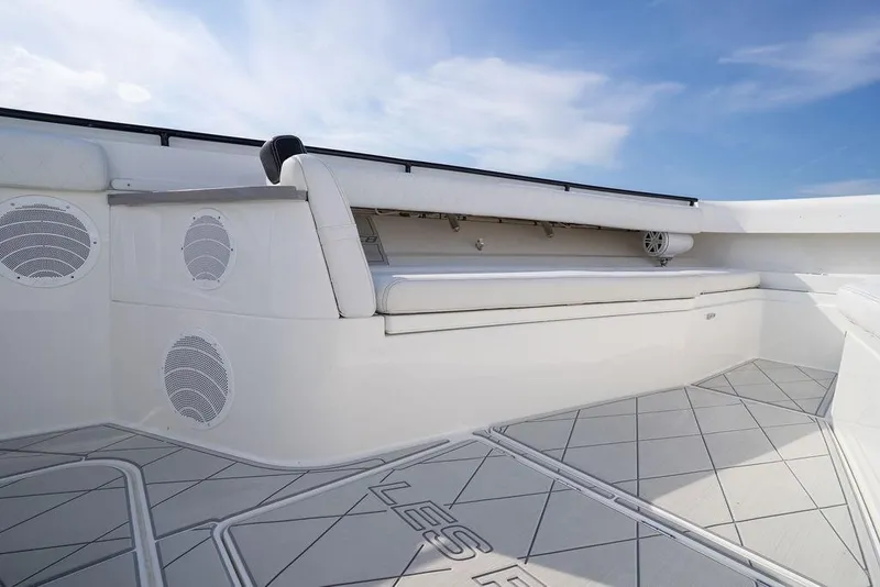 Slide: The Image of 2019 HCB 53 boat interior with cushioned seating and speakers under a blue sky. - 48