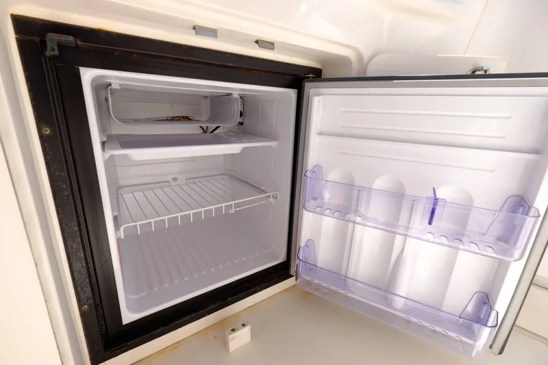 Slide: The Image of Open refrigerator inside a 2000 Sea Ray 340 Sundancer boat, showing empty shelves. - 10