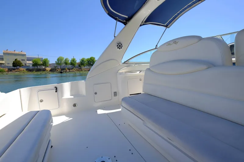 Slide: The Image of 2000 Sea Ray 340 Sundancer boat interior with white seating and blue canopy. - 11