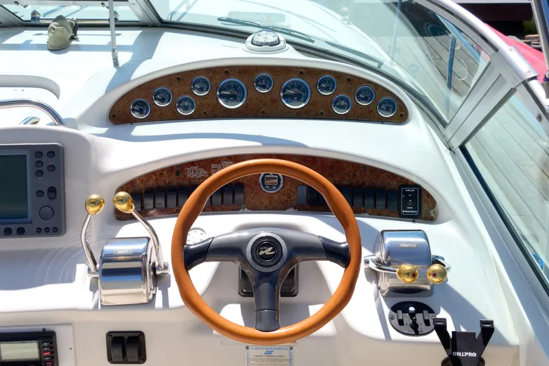 Slide: The Image of Control panel of a 2000 Sea Ray 340 Sundancer boat with gauges and steering wheel. - 13