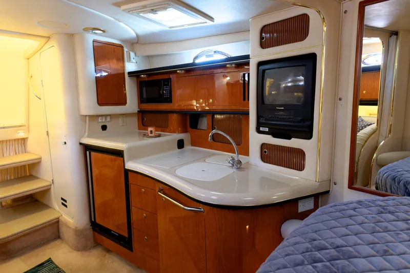 Slide: The Image of Interior of 2000 Sea Ray 340 Sundancer yacht with kitchenette and cozy seating area. - 18