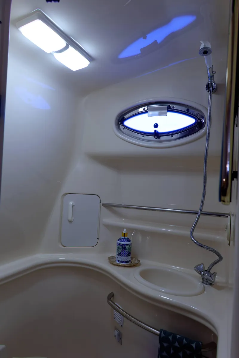 Slide: The Image of 2000 Sea Ray 340 Sundancer bathroom with shower, sink, and porthole window. - 27