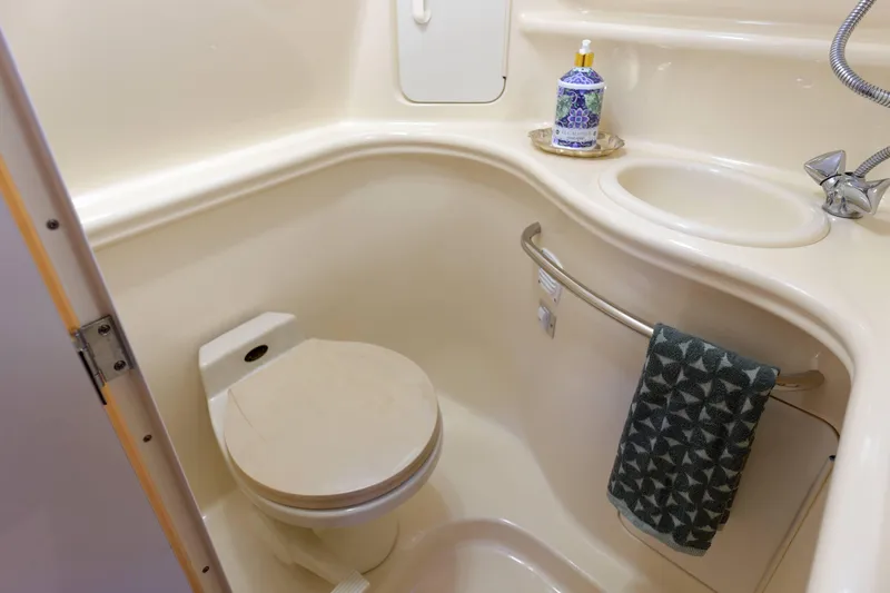 Slide: The Image of Compact bathroom in a 2000 Sea Ray 340 Sundancer yacht, featuring a toilet and sink. - 30