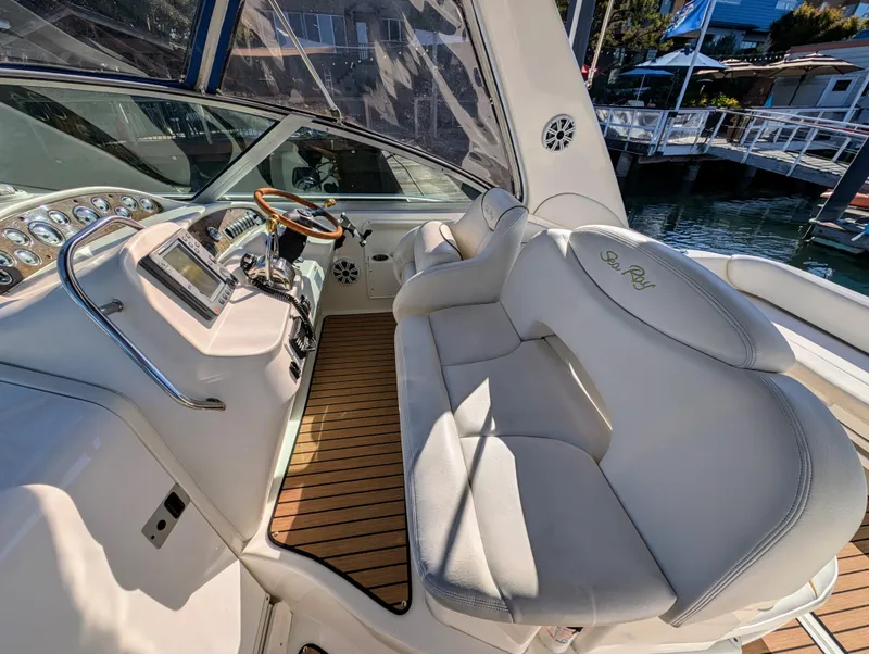 Slide: The Image of Cockpit of 2000 Sea Ray 340 Sundancer with white seating and wooden flooring. - 35